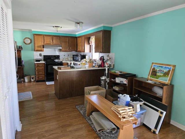 kitchen with under cabinet range hood, dark wood-type flooring, black appliances, and a peninsula