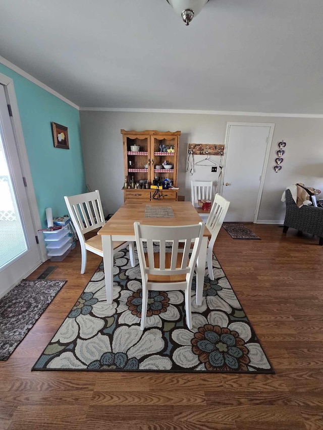 dining area featuring wood finished floors and ornamental molding