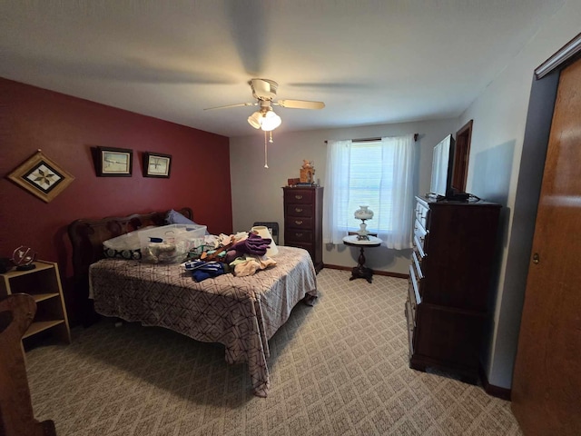 bedroom with light colored carpet, baseboards, and ceiling fan