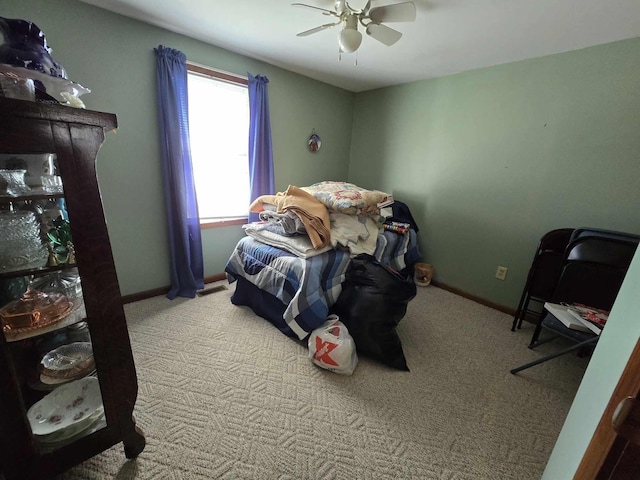 bedroom with a ceiling fan, baseboards, and carpet floors