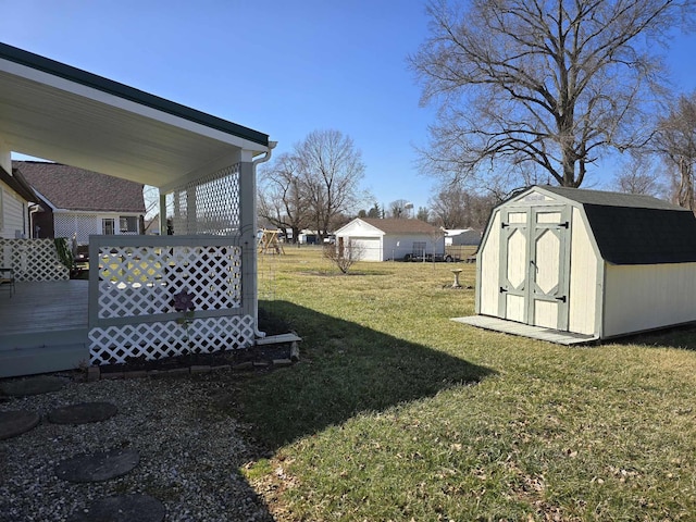 view of yard featuring a deck, a storage shed, and an outdoor structure