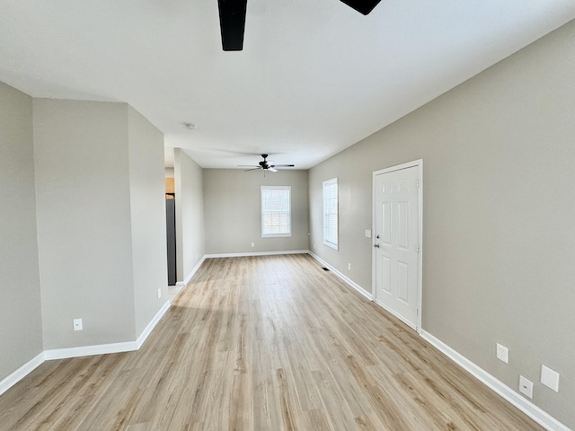 unfurnished room with a ceiling fan, light wood-type flooring, and baseboards