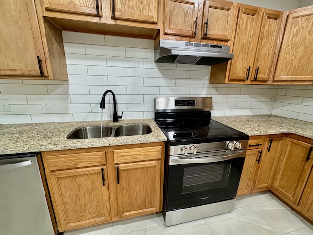 kitchen featuring under cabinet range hood, backsplash, appliances with stainless steel finishes, and a sink