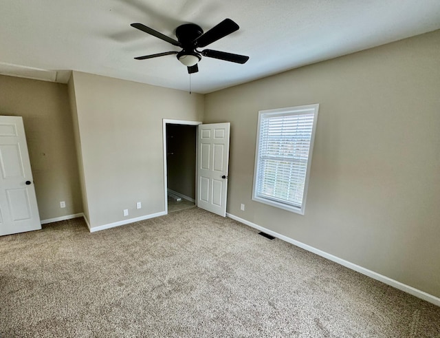 unfurnished bedroom featuring visible vents, a ceiling fan, baseboards, and carpet floors