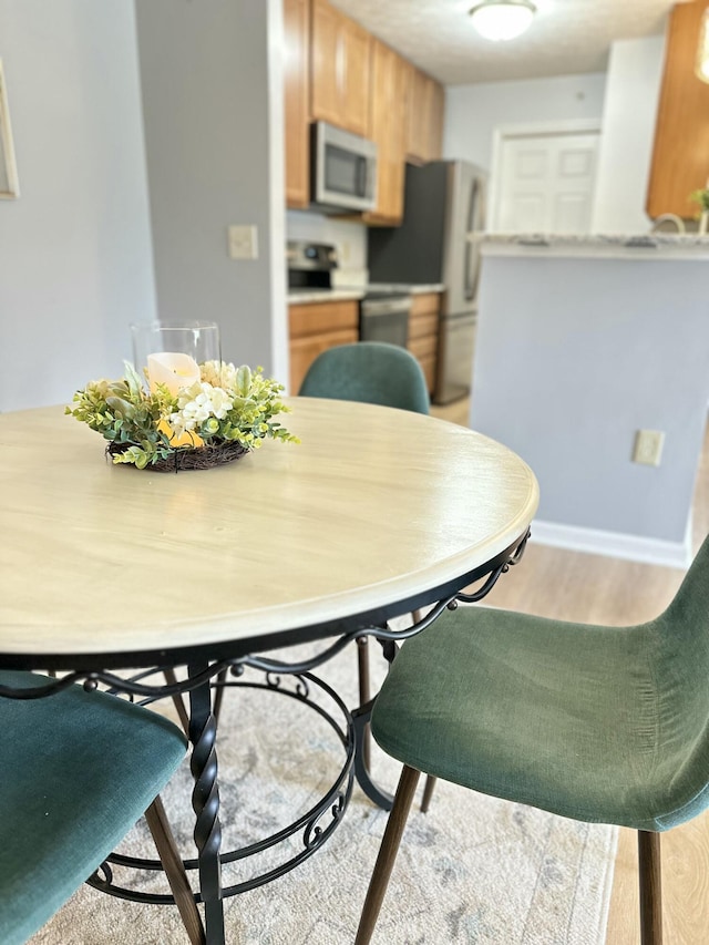 dining area featuring wood finished floors and baseboards