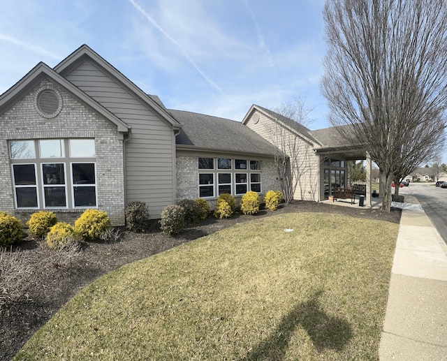 view of front of property featuring a front lawn and brick siding