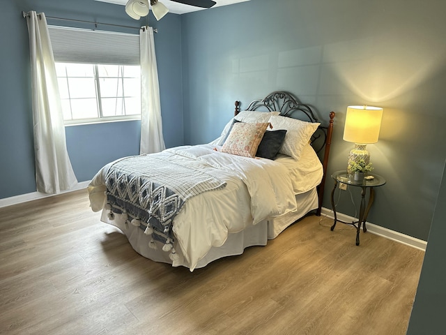 bedroom featuring a ceiling fan, wood finished floors, and baseboards