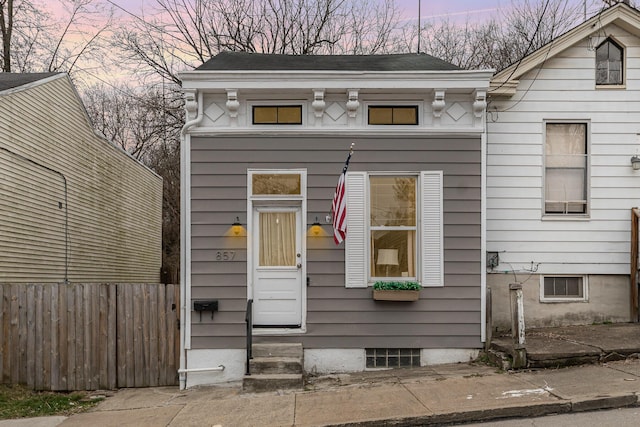 view of front facade with entry steps and fence