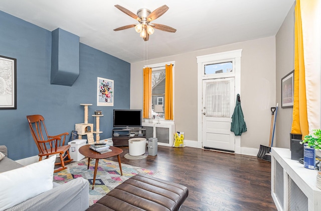 living room featuring dark wood finished floors, radiator, baseboards, and ceiling fan