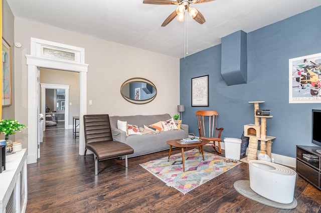 living area featuring baseboards, wood finished floors, and a ceiling fan