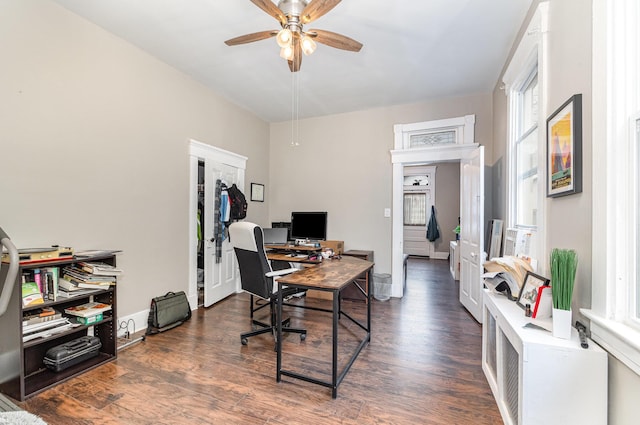 office area with a ceiling fan, wood finished floors, and baseboards