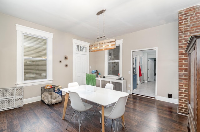 dining area with dark wood-type flooring and baseboards