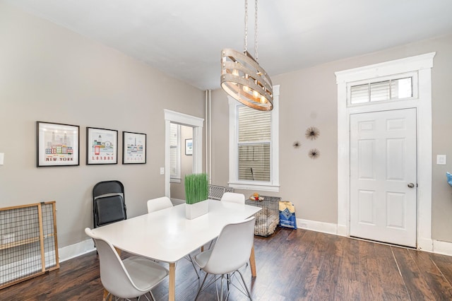 dining room with baseboards, a notable chandelier, a healthy amount of sunlight, and dark wood finished floors