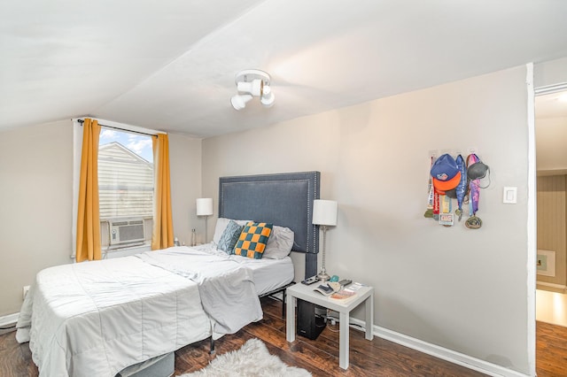 bedroom with cooling unit, baseboards, lofted ceiling, and wood finished floors