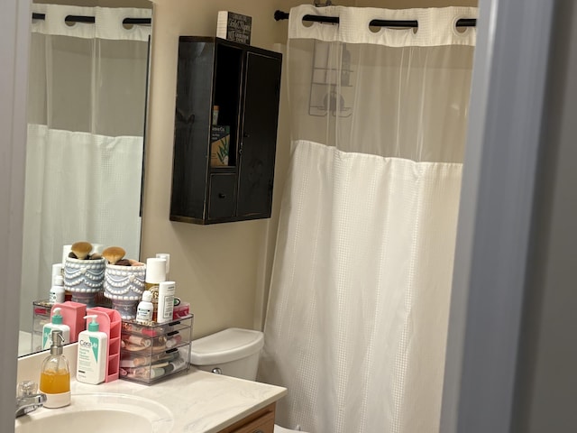 bathroom with vanity, curtained shower, and toilet