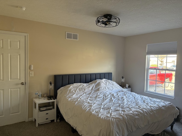 carpeted bedroom featuring visible vents and a textured ceiling