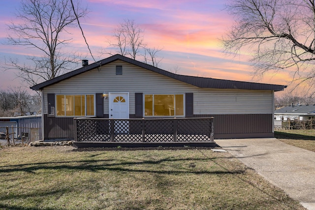 view of front of house with a yard and concrete driveway