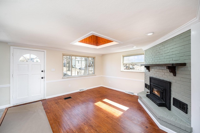 foyer entrance featuring plenty of natural light, a fireplace, and visible vents