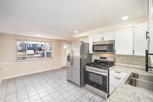 kitchen with baseboards, a sink, white cabinets, appliances with stainless steel finishes, and backsplash