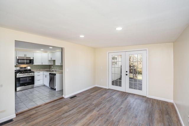 kitchen with french doors, visible vents, backsplash, and stainless steel appliances