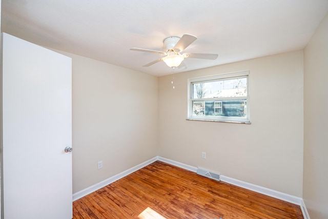 empty room featuring visible vents, ceiling fan, baseboards, and wood finished floors