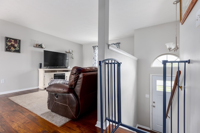 living room with a notable chandelier, wood finished floors, and baseboards