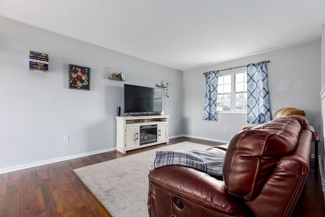 living room featuring dark wood-type flooring and baseboards