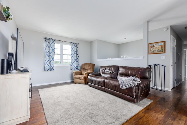 living area featuring dark wood-type flooring and baseboards