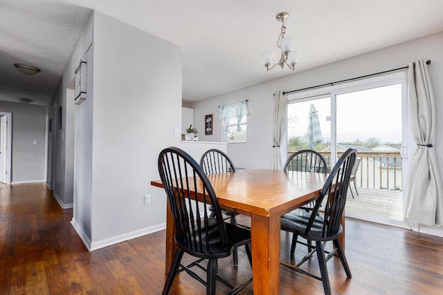 dining room featuring baseboards, dark wood-type flooring, and a chandelier