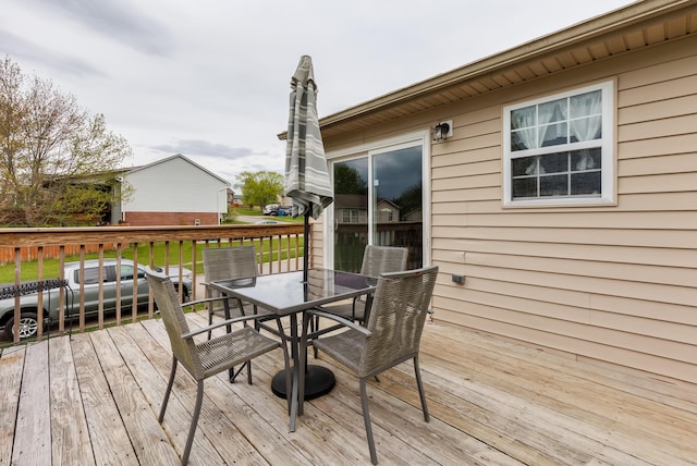 deck featuring outdoor dining space and a yard