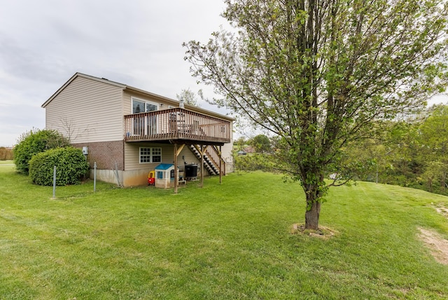 rear view of house featuring stairway, cooling unit, a lawn, and a wooden deck