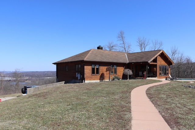 back of property featuring a chimney, a lawn, a shingled roof, and a sunroom