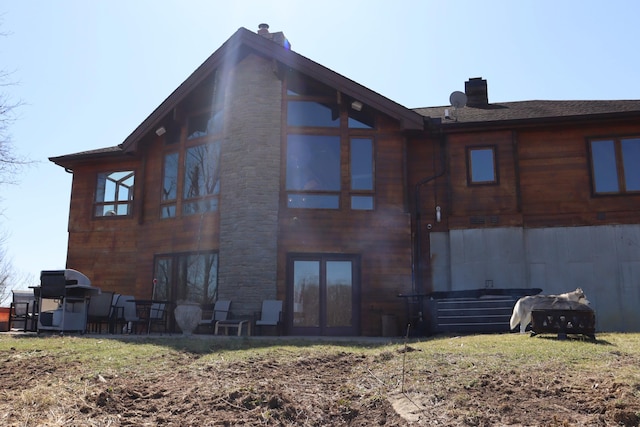 back of house featuring french doors, a chimney, and a sunroom