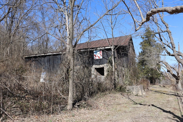 view of home's exterior with a barn and an outbuilding