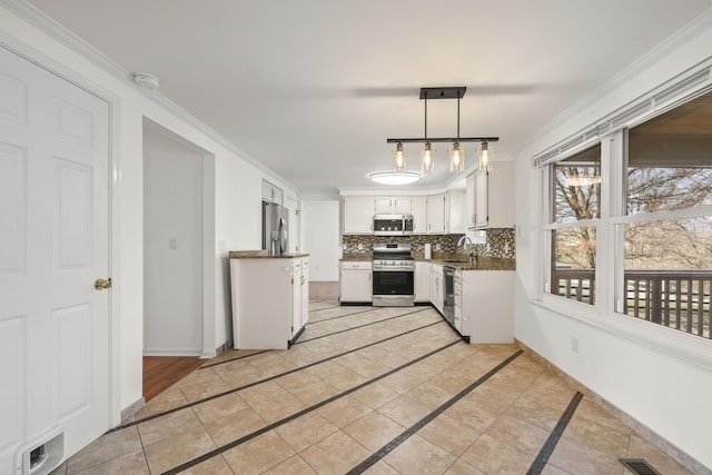 kitchen featuring visible vents, baseboards, ornamental molding, decorative backsplash, and appliances with stainless steel finishes