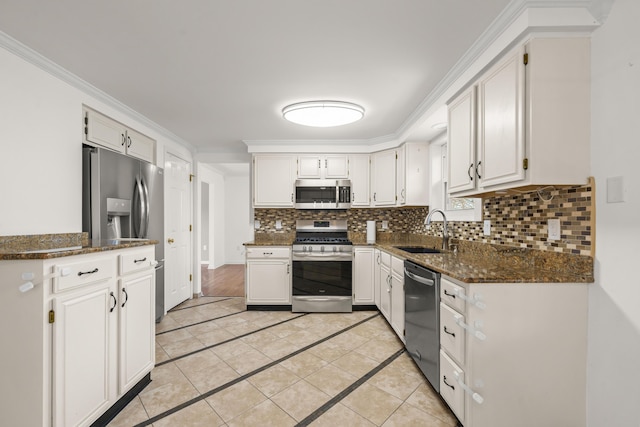 kitchen with crown molding, light tile patterned floors, decorative backsplash, stainless steel appliances, and a sink