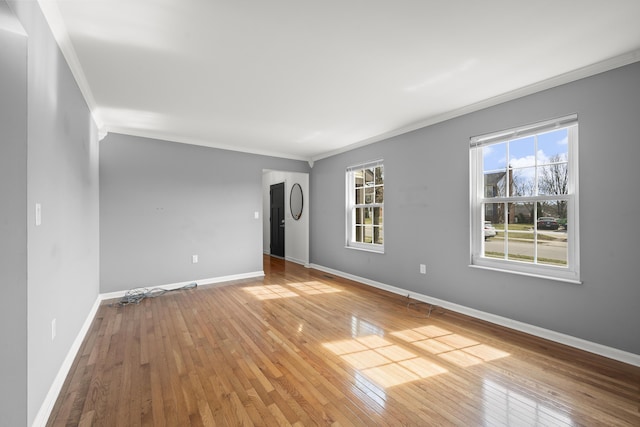 unfurnished room featuring baseboards, ornamental molding, and hardwood / wood-style flooring