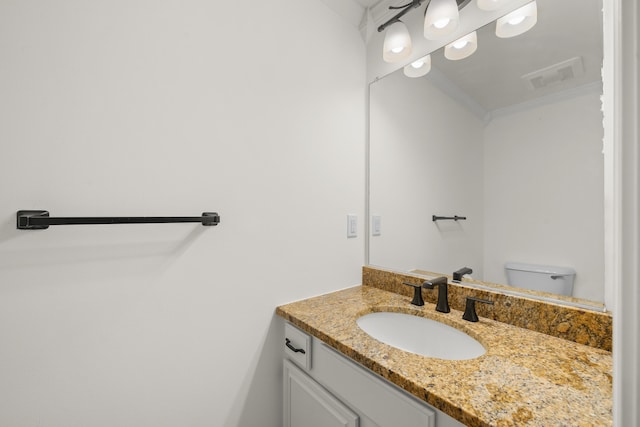 half bath with visible vents, toilet, vanity, and ornamental molding