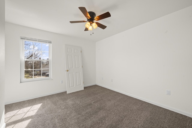 carpeted spare room with a ceiling fan and baseboards