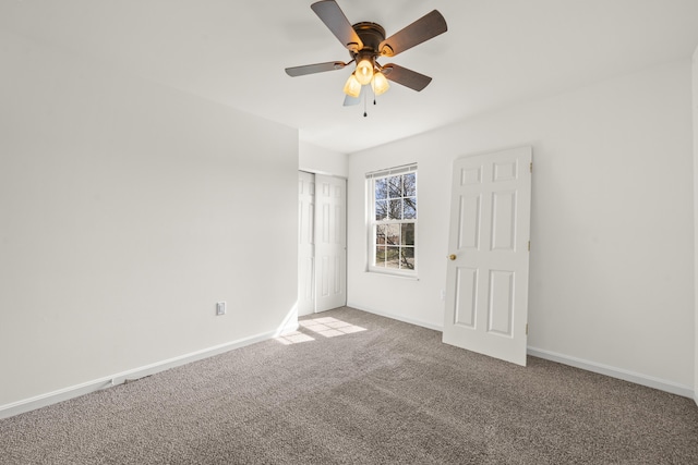 unfurnished bedroom featuring a closet, baseboards, carpet, and a ceiling fan