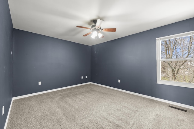 spare room featuring visible vents, baseboards, carpet, and a ceiling fan