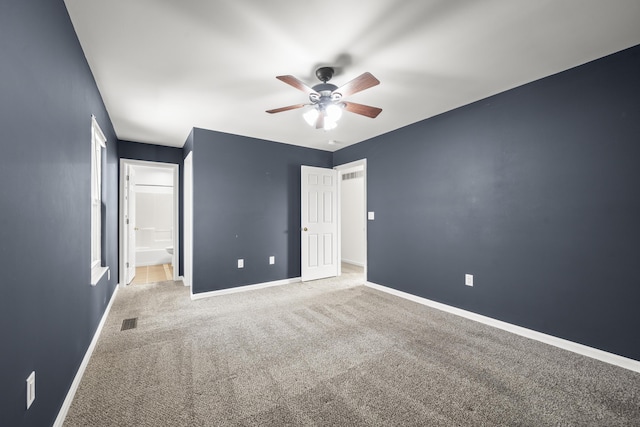 unfurnished bedroom with visible vents, a ceiling fan, ensuite bathroom, carpet flooring, and baseboards