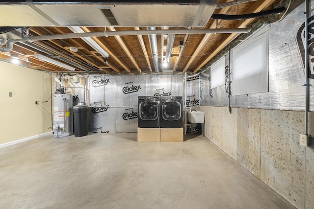 unfinished below grade area with a sink, water heater, and washer and clothes dryer