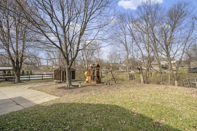 view of yard with fence, an outdoor structure, and a playground