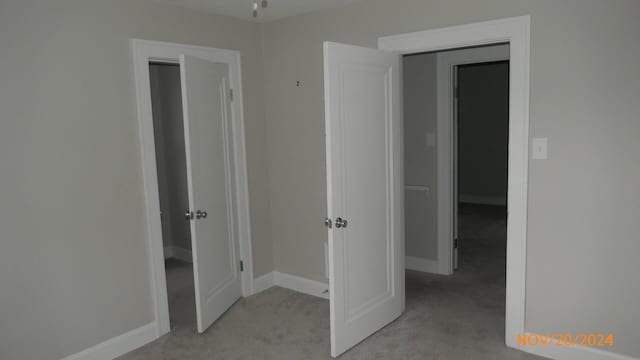 interior space with light carpet and baseboards