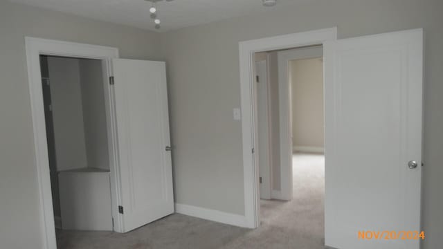 unfurnished bedroom with baseboards and light colored carpet