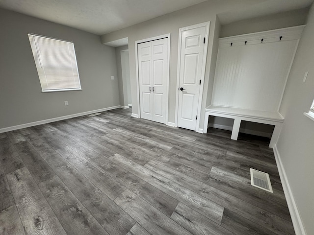 mudroom with baseboards, visible vents, and dark wood-style floors