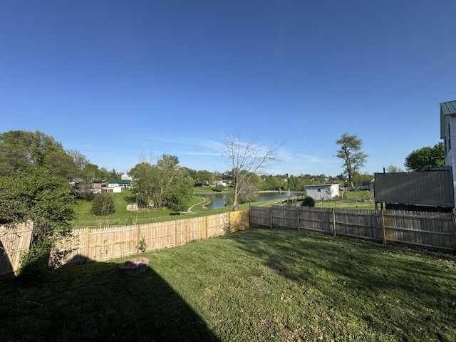 view of yard featuring a water view and a fenced backyard