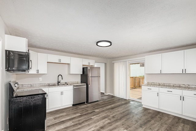 29 Race St, Dry Ridge, KY 41035 - kitchen featuring stainless steel appliances, a textured ceiling, dark wood finished floors, white cabinets, and light stone counters