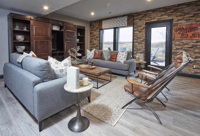 living area with recessed lighting, a barn door, and wood finished floors